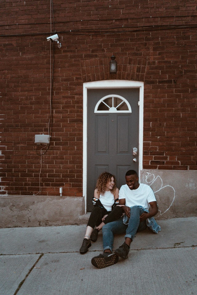 smiling-man-and-woman-sitting-beside-door-2719510